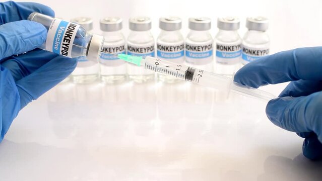 close up gloved hands fill syringe from  vial with monkeypox vaccine