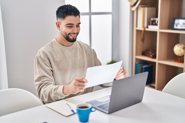 Young arab man sitting on table studying at home