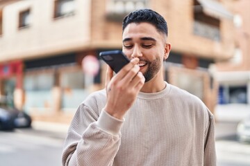 Young arab man smiling confident talking on the smartphone at street