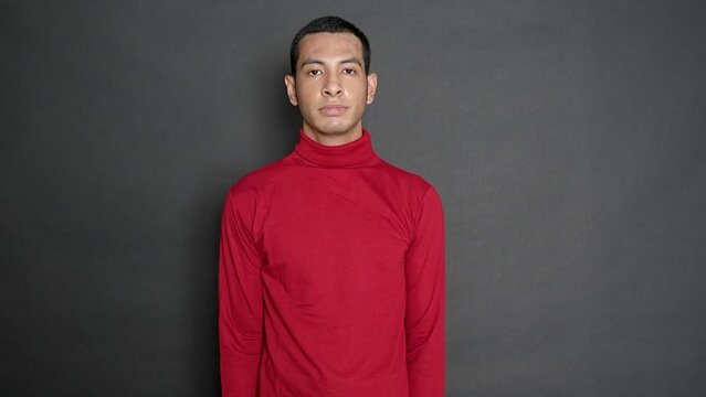 Young man showing his clueless gesture on a black background