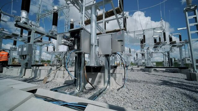 Many high voltage electrical insulators in power substation against blue sky background