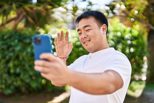 Young chinese man smiling confident having video call at park