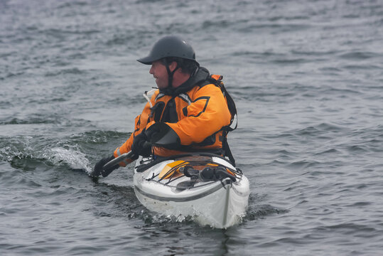 Kayak surfer on rough sea  by misty day on Nova Scotia coastlines, Canada