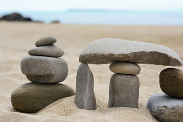 Fototapeta na wymiar Stacks of stones on beautiful sandy beach near sea, closeup