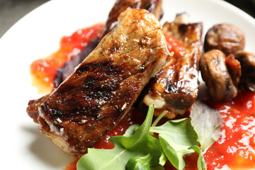 Delicious grilled ribs in plate, closeup view
