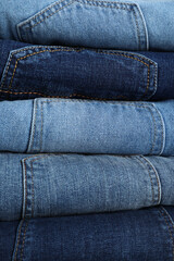 Stack of different jeans as background, closeup