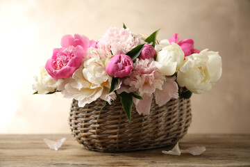 Fototapeta na wymiar Beautiful peony bouquet in wicker basket on wooden table