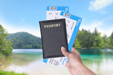 Woman holding passport with tickets and beautiful view of river on background