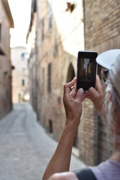 female tourist taking pictures in old town of Amandola, Italy