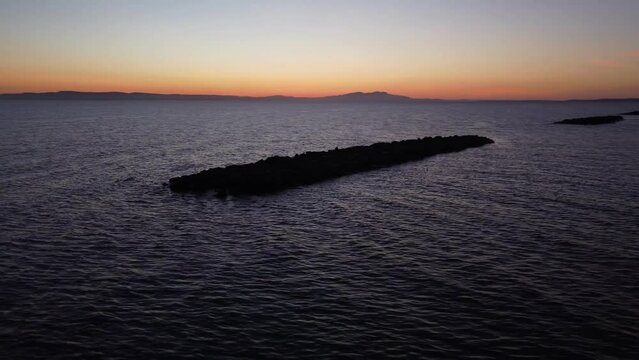 Drone Silhouette footage of breakwaters on sea and on dusk time.