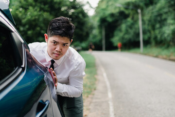Asian businessman pushing broken down car on the mountain road, Emergency call concept.