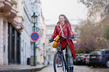 smiling woman outdoors on city street riding bicycle