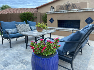 A travertine tiled pool deck with a spa and outdoor kitchen on a desert landscaped backyard in Arizona.