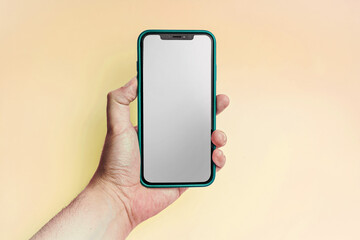 iPhone XS verde, sostenido por la mano sobre fondo amarillo. Pantalla transparente.