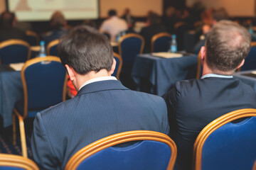 Audience at the modern conference hall listens to lecturer, people on a congress together listen to...