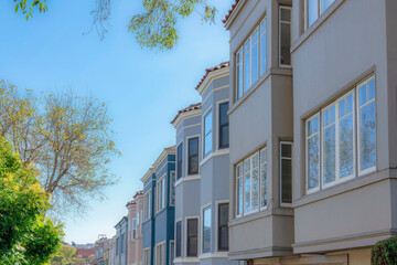 Row of townhouses on the right with bay windows against the clear sky in San Francisco, California