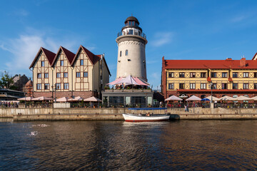 View of the embankment of the Pregolya River, the Fishing village and the Konigsberg Lighthouse on a sunny summer day, Kaliningrad, Russia