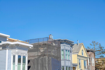 Unfinished house construction in the middle of residential house buildings in San Francisco, CA