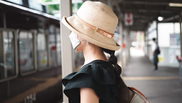 電車に乗る麦わら帽子の女性