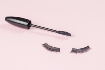 False eyelashes and mascara on a pink background.