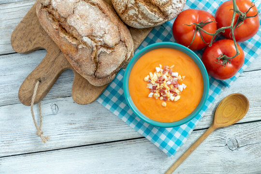 BOWL OF SALMOREJO CREAM, BREADS AND TOMATOES. TYPICAL SPANISH FOOD FROM CORDOBA. TOP VIEW.