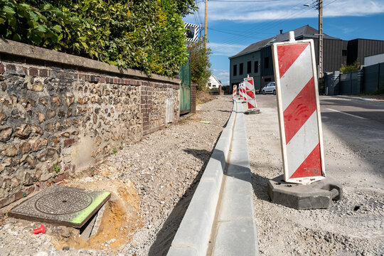 Réfection de trottoir et caniveau dans une rue. Pose de bordures en ciment