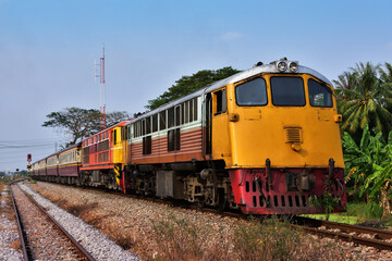 Fototapeta na wymiar Passenger train by diesel locomotive on the railway in Thailand