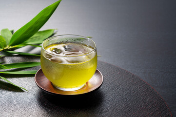 Cold Japanese green tea placed on a black tray.