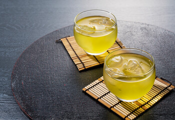 Cold Japanese green tea placed on a black tray.