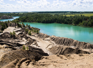 Fototapeta na wymiar Flooded quarry in Europe. The stone quarry lake with crystal clean water great for diving. Abandoned quarry filled with water serves as a beautiful natural swimming pool.