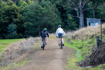 Family father and son riding bikes together on track