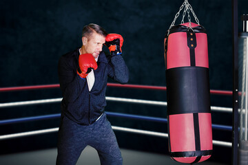 Man exercising with punching bag on ring