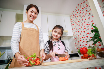 Portrait of mother and daughter enjoy preparing salad food together in kitchen at home