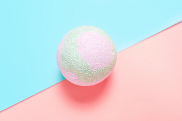 Colorful bath bomb on pink and blue background top view close-up.