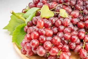 Red grape with leaves on wooden background, Bunch of fresh red grapes with leaves.