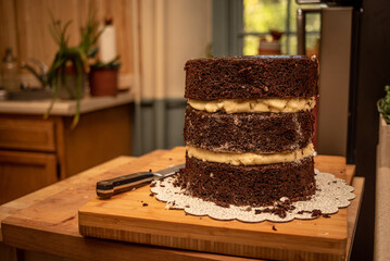 Unfrosted triple layer chocolate cake with peanut butter filling being baked in a home kitchen