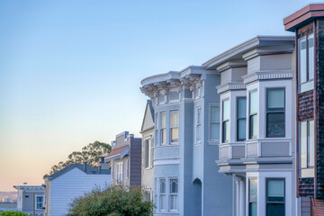 Row of large house buildings against the sunset skyline in San Francisco, California
