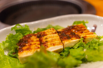 Tofu with Korean spicy soy and sesame oil sauce, salad. Food and travel concept. Close focus