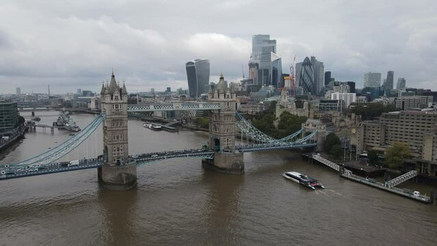Boat navigating in the Thames River through the Tower Bridge, London