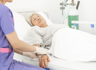 Female nurse intravenous caring to elderly patient