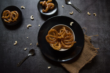 Popular Indian sweet jalebi or imarati made by deep frying in pure ghee served in a bowl. Top view, selective focus. 