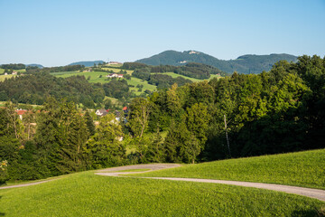 Lower Austria highlands landscape in summer, beautiful forests, meadows, farms, blue sky and puffy white clouds