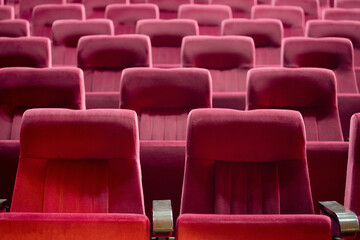 Empty red chairs for audience in the theater
