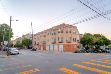 Intersection road in San Francisco, CA with apartment building at the corner with attached garages