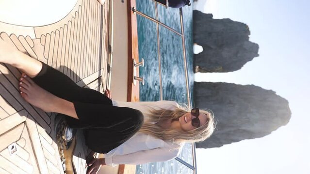Beautiful Blonde Tourist Exploring Capri's Faraglioni Rocks on Italy Vacation, Vertical