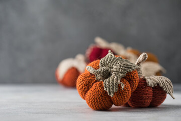  Knitted handmade pumpkins on a grey background. Autumn and coziness. DIY decor.