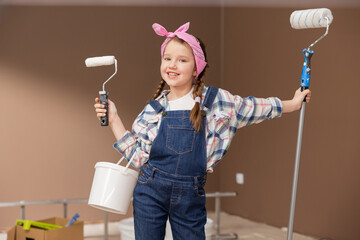 Sweet cheerful girl wearing a headscarf with braids on head, dressed in a shirt and dungarees,...
