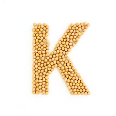 Capital letter K made from chickpea beans. Dry chick pea font. Alphabet made from gram . White...