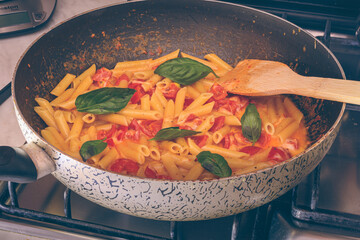 Pasta With Tomatoes And Cheese While Cooking
