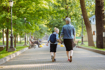 Fototapeta premium mother and son going to school holding hands